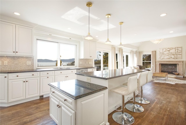 kitchen with a kitchen bar, tasteful backsplash, dark wood finished floors, open floor plan, and a center island