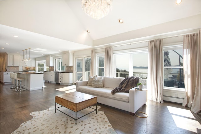 living area featuring dark wood finished floors, recessed lighting, an inviting chandelier, high vaulted ceiling, and a baseboard radiator