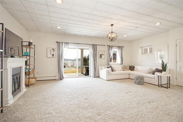 carpeted living room featuring recessed lighting, a chandelier, baseboard heating, and a glass covered fireplace