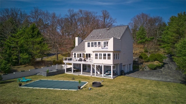 rear view of house featuring a yard, a patio area, fence, and a chimney