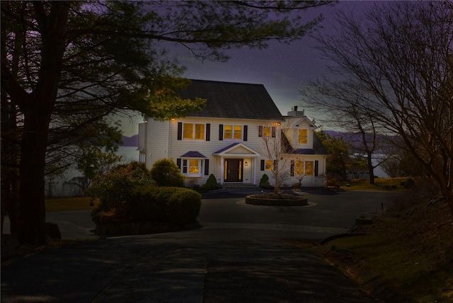 view of front of house with a chimney and driveway