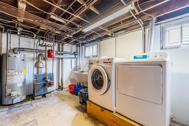 clothes washing area featuring washing machine and clothes dryer, a heating unit, water heater, laundry area, and a sink