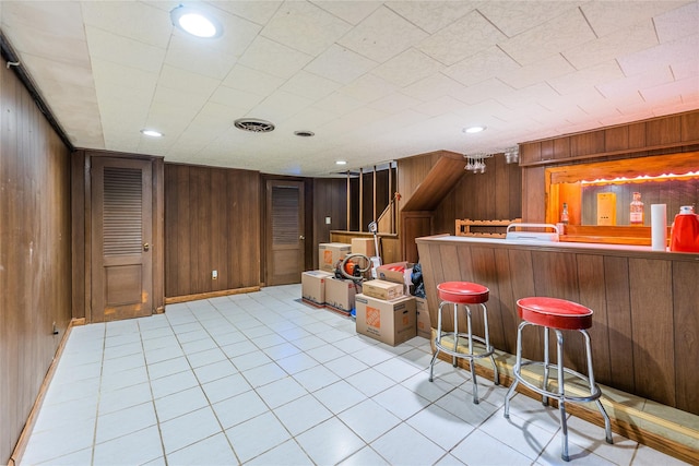 bar featuring visible vents, recessed lighting, stairway, wood walls, and a dry bar