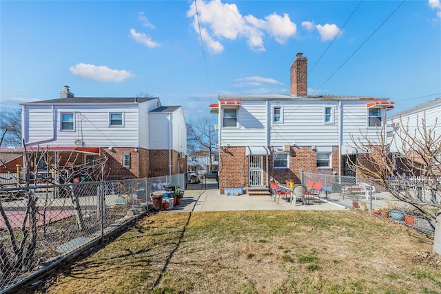 back of property with brick siding, entry steps, a chimney, a fenced backyard, and a patio