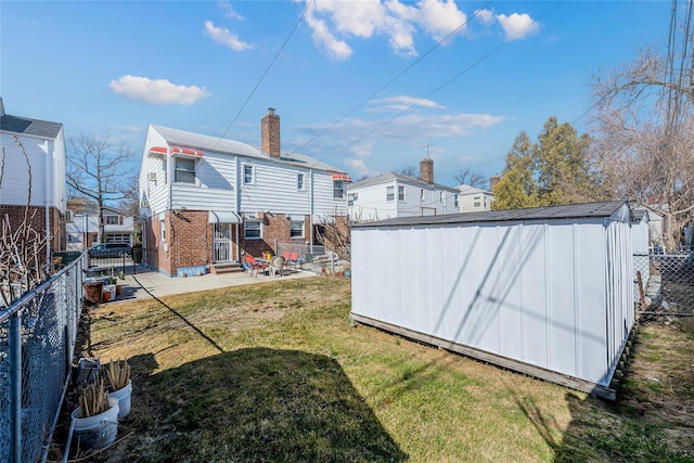 rear view of property featuring a fenced backyard, entry steps, a storage unit, a lawn, and brick siding