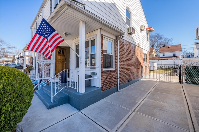 view of front of property featuring a gate, fence, and brick siding