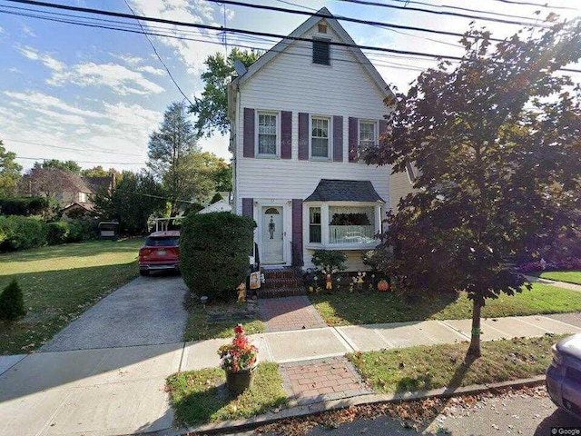 traditional-style house with driveway and a front lawn