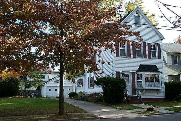 view of front of property with an outbuilding, a garage, a front yard, and driveway