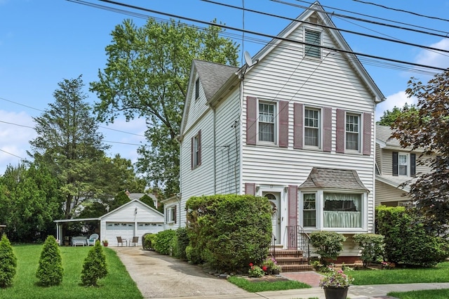 73 Spruce Ave, Floral Park, NY 11001 - view of front facade featuring an outdoor structure, a detached garage, a front yard, roof with shingles, and entry steps