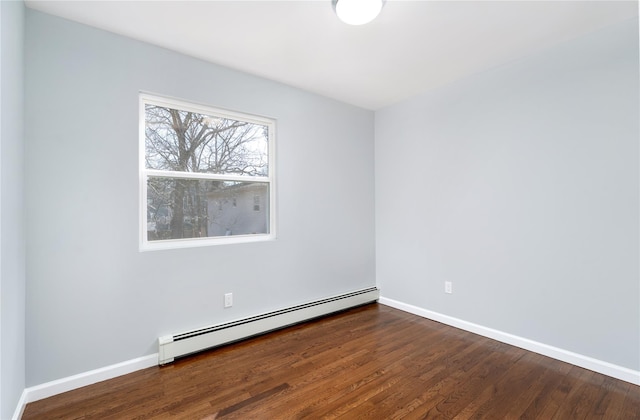 unfurnished room featuring baseboards, baseboard heating, and wood finished floors