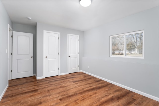 unfurnished bedroom with wood finished floors and baseboards