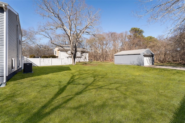 view of yard featuring an outbuilding, central air condition unit, and fence