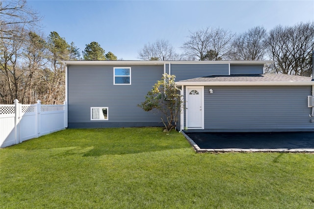 back of house with a lawn and fence