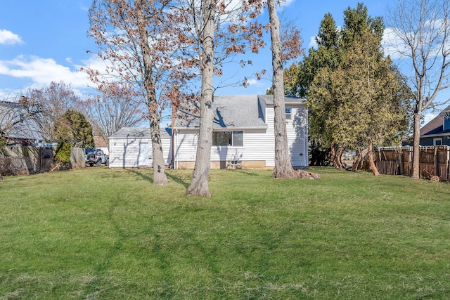 view of yard featuring an outbuilding, a shed, and fence