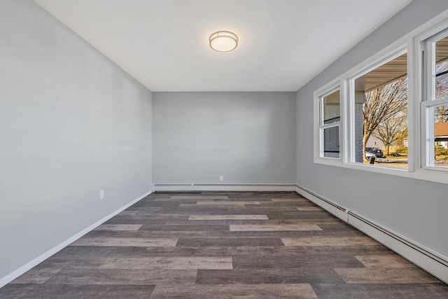 empty room with dark wood finished floors, baseboards, and a baseboard radiator