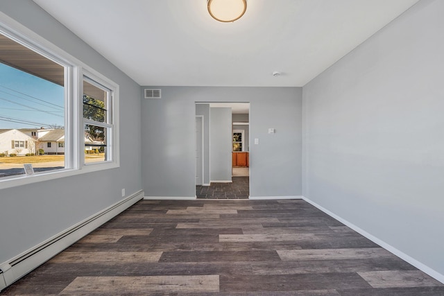 empty room with visible vents, baseboards, baseboard heating, and wood finished floors