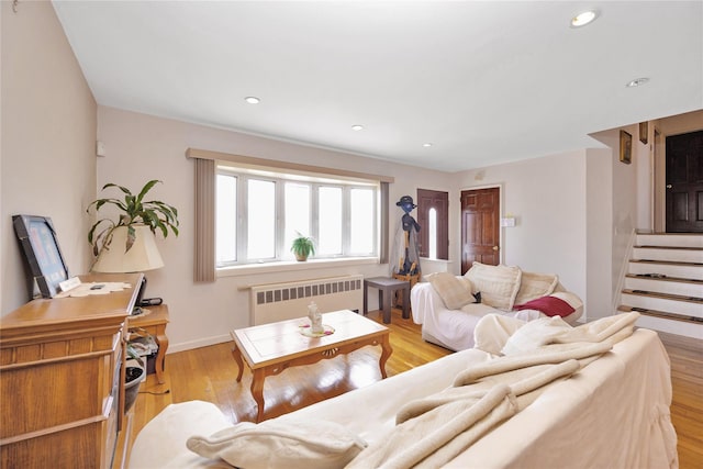 living room featuring stairway, radiator, baseboards, recessed lighting, and light wood-type flooring