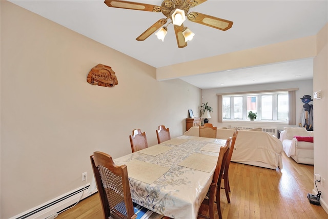 dining space with light wood finished floors and baseboard heating