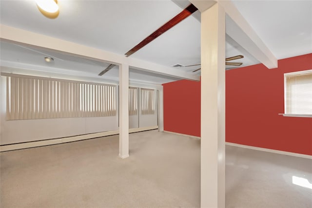 basement featuring visible vents, baseboards, ceiling fan, and carpet floors