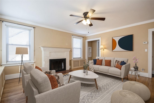 living room featuring a ceiling fan, light wood-type flooring, and ornamental molding