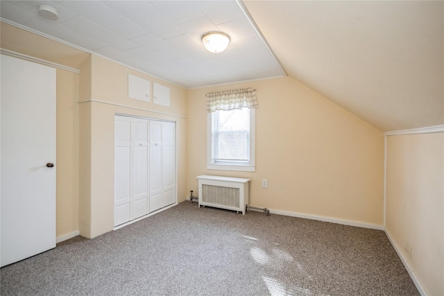 additional living space with carpet flooring, lofted ceiling, radiator, and baseboards