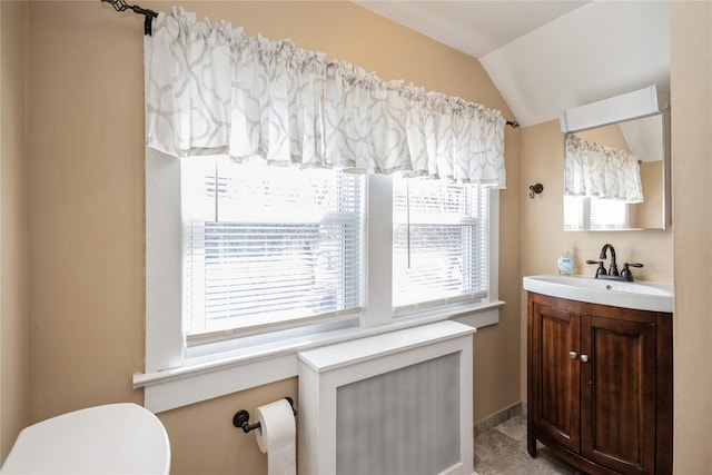 bathroom featuring toilet, lofted ceiling, radiator heating unit, baseboards, and vanity