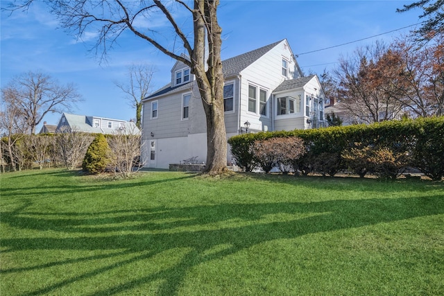 view of home's exterior with a lawn and roof with shingles