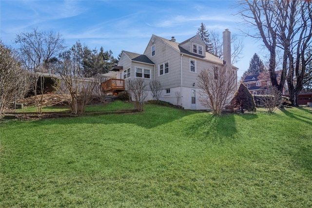 view of property exterior with a deck, a lawn, and a chimney