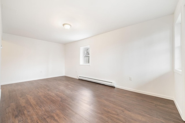 empty room featuring dark wood-type flooring, baseboards, and a baseboard radiator