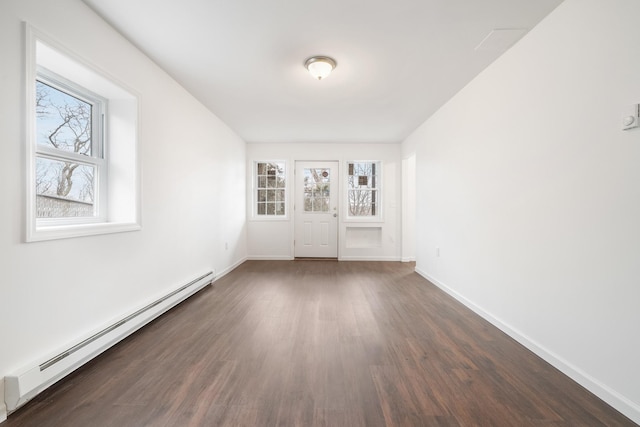 spare room featuring baseboards, dark wood-style flooring, and baseboard heating