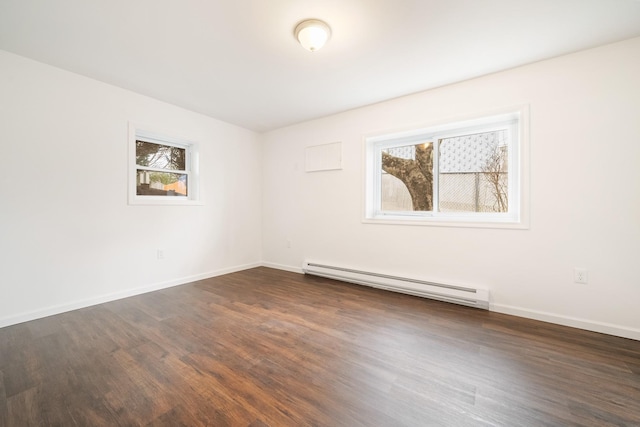 empty room featuring plenty of natural light, baseboards, a baseboard heating unit, and dark wood-type flooring