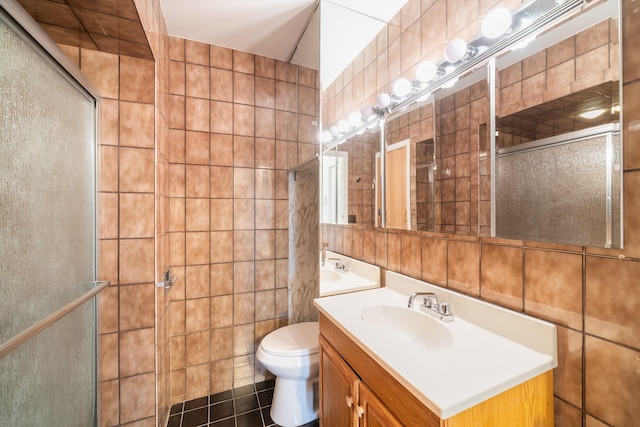 bathroom featuring tiled shower, toilet, tile walls, and vanity