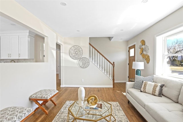 living area featuring stairs, plenty of natural light, and wood finished floors