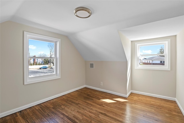 bonus room featuring vaulted ceiling, visible vents, baseboards, and hardwood / wood-style floors