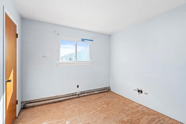 unfurnished room featuring a baseboard heating unit