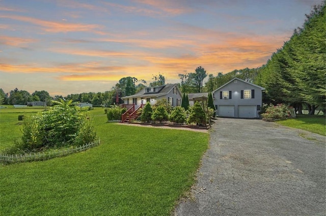 view of front of home featuring driveway, a yard, and an attached garage
