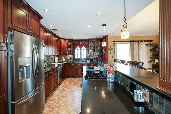 kitchen with pendant lighting, decorative backsplash, recessed lighting, stainless steel appliances, and glass insert cabinets