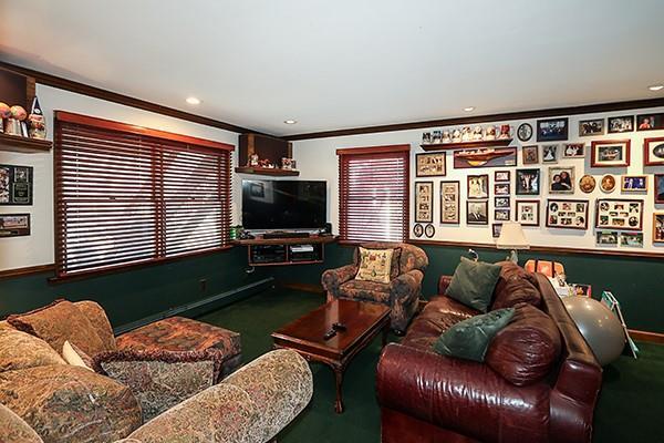 carpeted living area with recessed lighting, baseboards, and crown molding