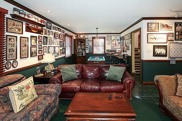 living room featuring tile patterned floors and crown molding