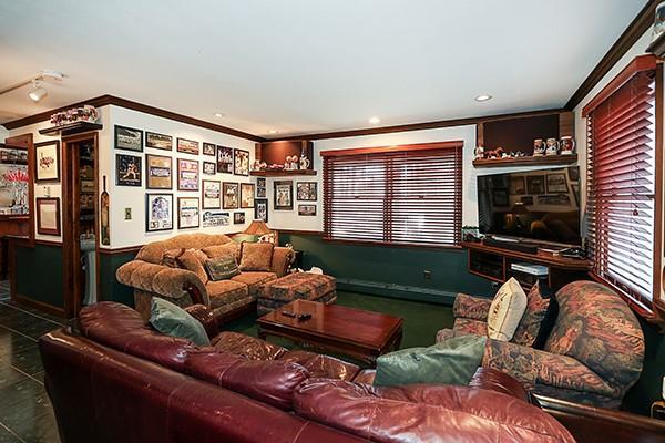 tiled living area with recessed lighting and crown molding