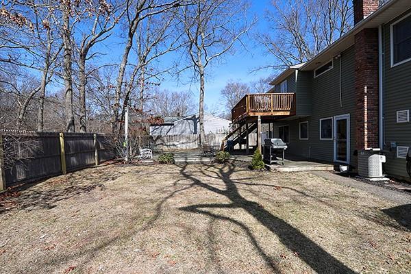 view of yard featuring cooling unit, a wooden deck, a fenced backyard, stairs, and a patio area