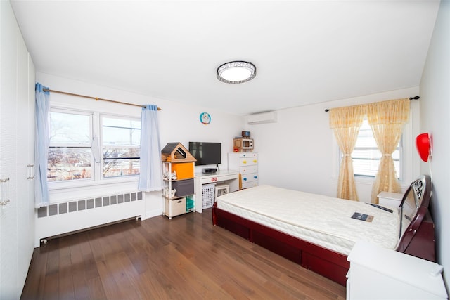 bedroom with an AC wall unit, radiator, and dark wood-style flooring