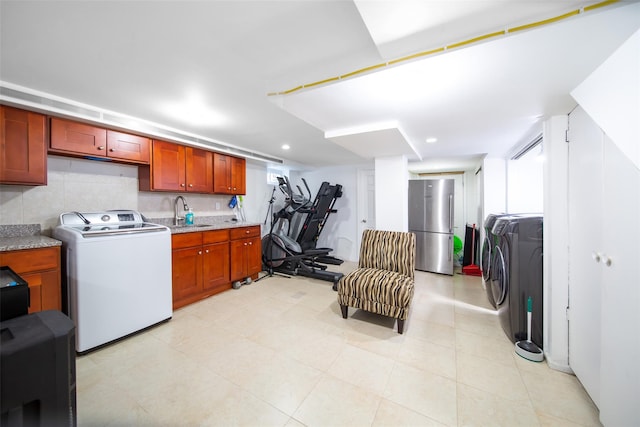 kitchen featuring washer / clothes dryer, recessed lighting, freestanding refrigerator, and a sink