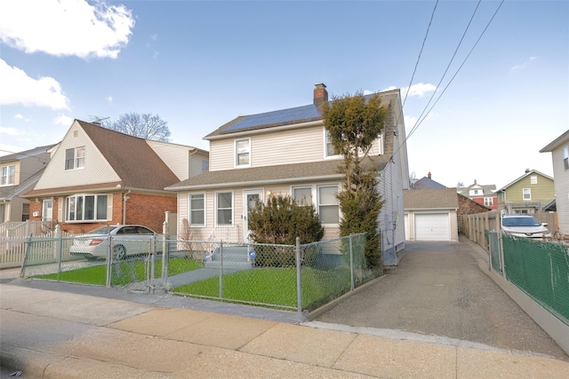 view of front of house with a front lawn, a fenced front yard, roof mounted solar panels, a garage, and a gate