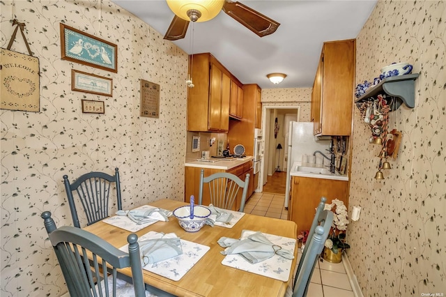 dining area featuring light tile patterned floors, ceiling fan, and wallpapered walls