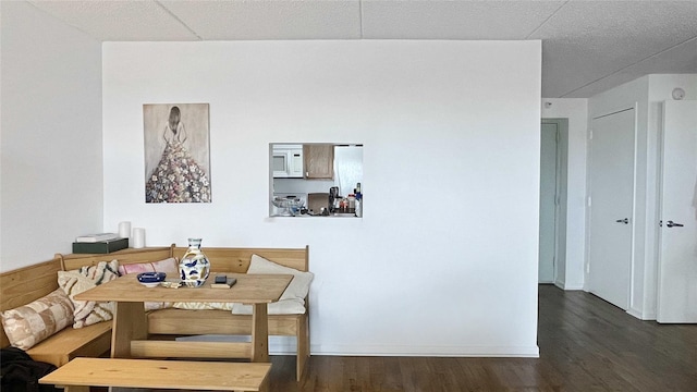 dining area with breakfast area, baseboards, and wood finished floors