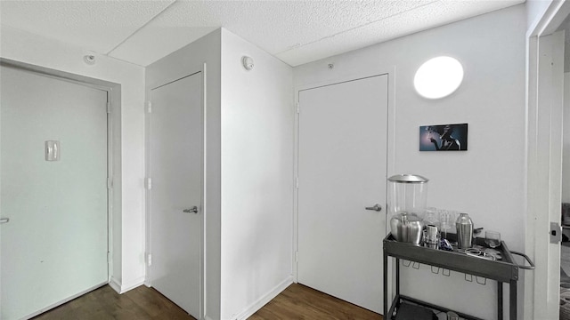 hallway featuring a textured ceiling and dark wood-style flooring