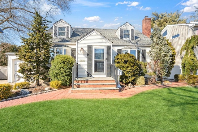 cape cod home featuring a front lawn, roof with shingles, and a chimney