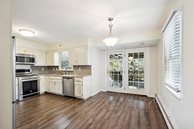 kitchen with dark wood-type flooring, a baseboard radiator, light countertops, stainless steel appliances, and a sink