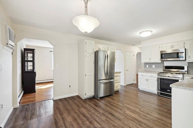 kitchen featuring dark wood-style floors, arched walkways, light countertops, appliances with stainless steel finishes, and a baseboard heating unit